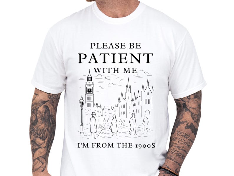 Relaxed moss green unisex t shirt worn by a tattooed model, featuring a vintage black city sketch and bold lettering reading I'm from the 1900s, soft worn aesthetic and cozy fit, a funny vintage shirt and retro humor tee, novelty graphic tee and sarcastic t shirt gift for him, dad, millennial or Gen X old soul humor apparel