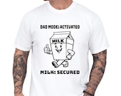 Photo 1 of 8: Funny dad shirt featuring a playful milk carton art graphic with Dad Mode Activated and Milk Secured, a cozy milk carton tee and gag gift for dad with cool papa outfit vibes for Father’s Day or a snack quest design lover