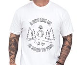 Photo 1 of 8: Soft moss Comfort Colors cotton tee worn by a man, sarcastic dad joke tee that reads "A guy like me is hard to find" with invisible man sketch, pine trees and boots, punny graphic humor cotton shirt ideal for casual weekend wear or Father's Day gift