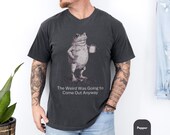 Photo 2 of 8: Model wearing a soft blue unisex t shirt featuring a vintage sketch frog holding a coffee mug and the sarcastic line The Weird Was Going to Come Out Anyway, a funny frog shirt and frog graphic tee with weird humor and introvert vibes, cozy casual fit, quirky gift for him