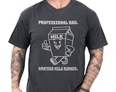 Photo 1 of 8: Funny dad shirt in a vintage black tee style, featuring a smiling milk carton art character with the text Professional Dad and Amateur Milk Runner, a playful fathers day gift with cool papa outfit energy and a clever cereal run joke for everyday dad humor society