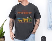 Photo 4 of 10: Five unisex short-sleeve crewneck shirts in Black, White, Pepper, Moss and Blue Jean shown on a relaxed male model to show fit and soft cotton drape, perfect mockup for a funny retro tee, pixel art tshirt, unisex funny shirt or sarcastic "please be patient" aging humor gift for Gen X gamers