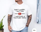 Photo 4 of 8: Model wearing a funny dad tee shown in five comfort-dye colors — Black, White, Pepper, Moss, Blue Jean — soft cotton fabric with relaxed, cozy fit and worn-in vibe, ideal fathers day present or birthday gag gift for the handyman dad who loves garage projects and YouTube repair jokes