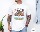 Photo 4 of 14: Male model wearing a white unisex t shirt featuring a playful, colorful raccoon graphic and the slogan Embrace your inner Trash Panda — a trash panda shirt and raccoon t shirt that's a funny animal tee and novelty graphic tee with soft casual fit, perfect animal lover gift or cool gift for him