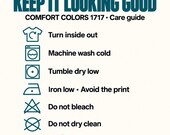 Photo 15 of 17: Care instructions for Comfort Colors 1717 t-shirts displayed with icons for washing, drying, and ironing.