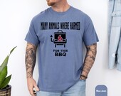 Photo 6 of 8: Soft blue jean unisex tee with relaxed fit and bold black grill icon, showing the cheeky 'Many animals where harmed for this BBQ' slogan — a playful many animals shirt and typo shirt with dark humor, a funny bbq shirt, grilling shirt and barbecue tee ideal as a meat lover gift for cookouts