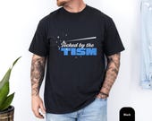 Photo 3 of 8: Black funny autism shirt on a model, featuring the playful phrase touched by the tism in bold blue lettering for a relaxed neurodivergent shirt look, a witty autism humor tee or ASD awareness gift with a clean modern style