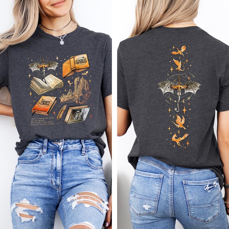 May include: Dark gray t-shirt featuring a fantasy book design on the front, with open books, a castle, and a dragon. The back of the shirt has a dragon and star design. The shirt is paired with blue jeans.