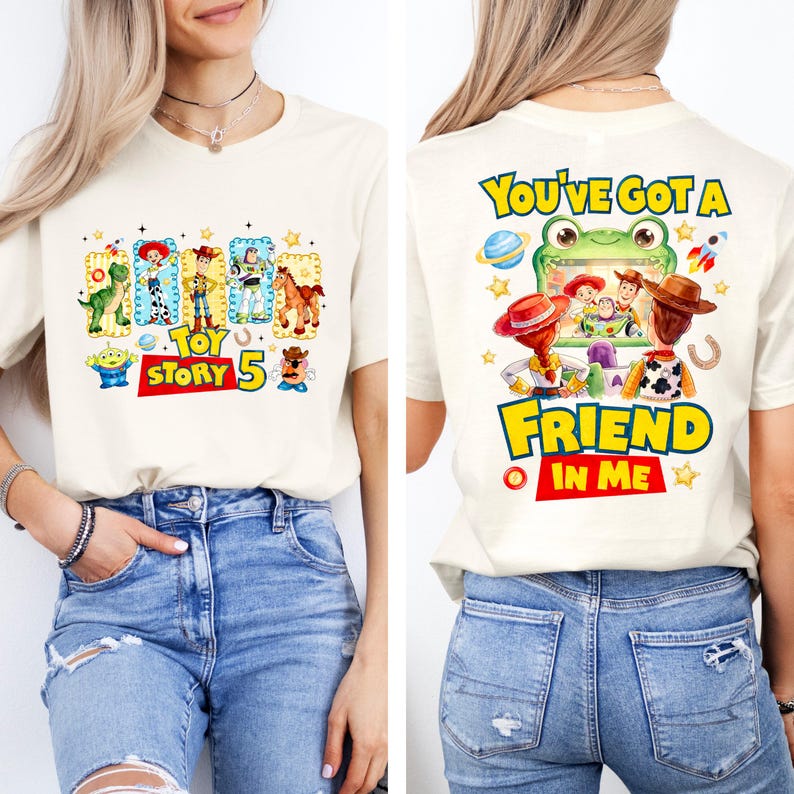 May include: A cream-colored t-shirt featuring Toy Story graphics. The front displays characters in frames with the text "TOY STORY 5". The back shows characters watching a screen with the text "YOU'VE GOT A FRIEND IN ME" and a green frog frame.