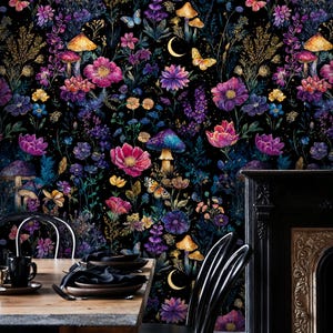 May include: A colourful floral wallpaper design with a dark background, showcasing flowers, mushrooms, butterflies, and a crescent moon. The colour scheme includes pink, purple, blue, and yellow. The wallpaper is used as a backdrop for a dining table and chairs.
