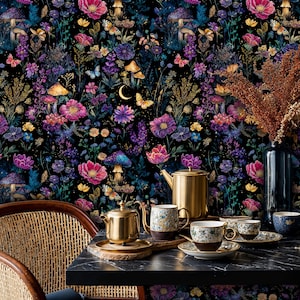 May include: A colourful floral wallpaper with a dark backdrop, showcasing flowers, mushrooms, and butterflies. A gold teapot, teacups, and saucers are arranged on a black table. A wicker chair and a vase with dried flowers are also visible.