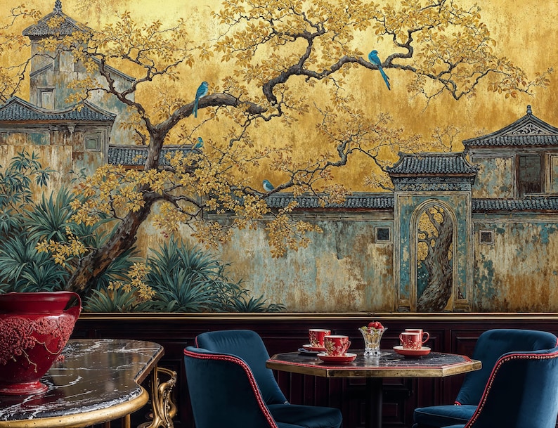 May include: A detailed mural depicting an Asian garden scene with a golden yellow background. The mural features a tree with yellow leaves, blue birds, and traditional architecture. The scene is complemented by a table setting with red cups and blue velvet chairs.