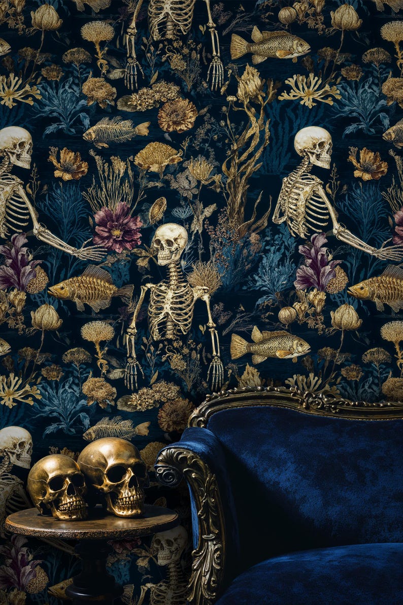 K&ouml;nnte beinhalten: Dunkelblaue Tapete mit einem sich wiederholenden Muster aus Skeletten, Fischen und floralen Elementen in Gold und Lila. Zwei goldene Totenk&ouml;pfe stehen auf einem kleinen Tisch vor einem blauen Samtsessel.
