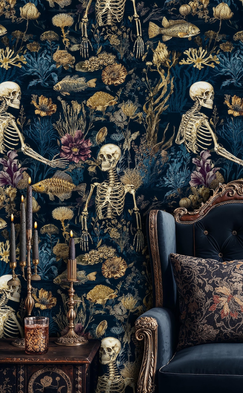K&ouml;nnte beinhalten: Dunkelblaue Tapete mit einem botanischen und Skelett-Design. Goldfarbene Fisch- und Blumenelemente vor tiefblauem Hintergrund. Ein goldener Kerzenst&auml;nder mit schwarzen Kerzen und ein blauer Sessel im Vordergrund.