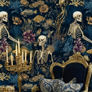 K&ouml;nnte beinhalten: Dunkelblaue Tapete mit goldenen Skeletten, Fischen und floralen Elementen. Ein goldener Kerzenleuchter mit brennenden Kerzen und ein blauer Samtstuhl mit goldenen Verzierungen im Vordergrund. Dekorative Kissen mit goldenen Mustern vervollst&auml;ndigen das Bild.