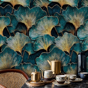 Puede incluir: Papel pintado con hojas de ginkgo teal y dorado. Una tetera dorada, tazas y platillos están sobre una mesa negra. Una silla de mimbre está a la izquierda. El papel pintado tiene un fondo verde azulado oscuro con vetas doradas.