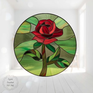May include: Circular stained glass art featuring a red rose with green leaves and stem. The rose is the focal point, surrounded by green and yellow glass. The artwork is framed in black and has the words "Digital Download PDF, PNG".