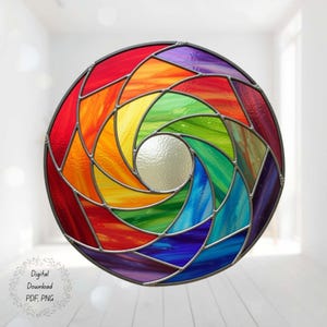 以下が含まれることがあります： 虹色のスパイラルデザインの丸いステンドグラスの窓。窓は赤、オレンジ、黄色、緑、青、紫など、鮮やかな色の配列が特徴です。ガラスは幾何学的な形に分割され、暗い金属のフレームで囲まれています。