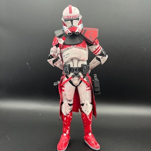 Pu&ograve; includere: Figura d'azione dettagliata di un clone trooper di Star Wars. La figura &egrave; prevalentemente bianca con dettagli rossi sul casco, sulle spalle e sulle gambe. Presenta cinture nere e un mantello rosso, con una fondina.