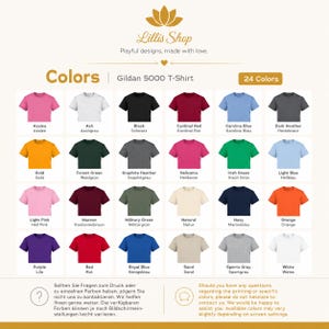 May include: A color chart for Gildan 5000 t-shirts from Lillis Shop, displaying 24 different shirt colors in a grid. Each color swatch is labeled with its name in English and German, including shades like Azalea, Black, Gold, and Navy.