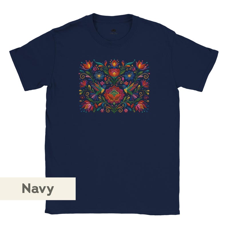 May include: A navy blue short-sleeve t-shirt featuring a central graphic print of colorful hummingbirds surrounded by vibrant red, orange, yellow, and blue flowers and green foliage. The design is symmetrical and detailed with intricate patterns.