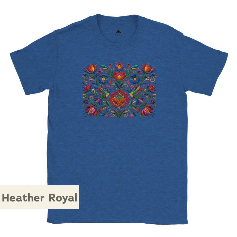 May include: A heather royal blue short-sleeve t-shirt featuring a central graphic print of colorful flowers and two hummingbirds in shades of red, orange, yellow, and green. The design is symmetrical with intricate floral patterns and foliage.