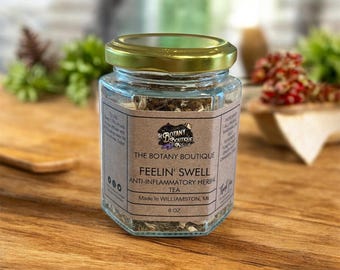 May include: A hexagonal glass jar with a gold lid, filled with herbal tea. The label reads "FEELIN' SWELL ANTI-INFLAMMATORY HERBAL TEA" from The Botany Boutique, made in Williamston, MI. The jar contains 170 grams of tea.