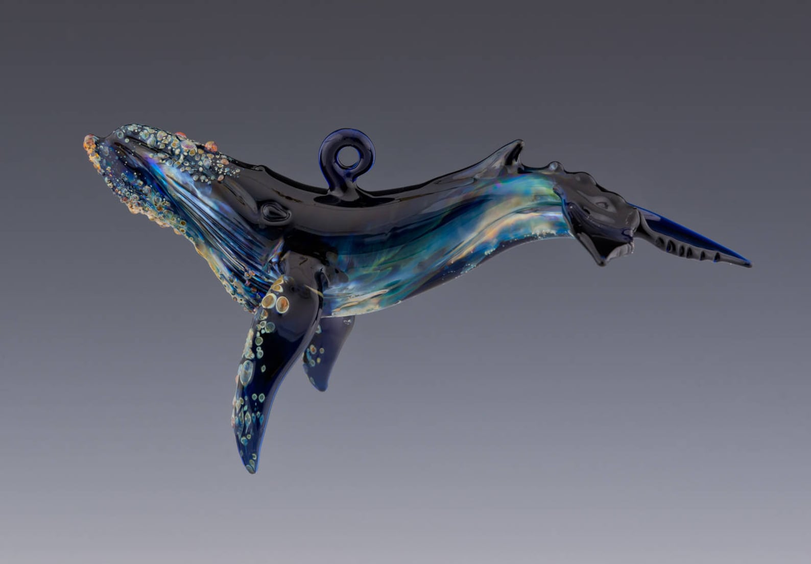 ceramic ornamental shaped as a whale.  Black and blue in color.