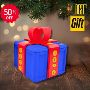 May include: A blue gift box with a red bow and accents. The box has yellow details and is decorated with a red ribbon. The image also includes a red 50% off tag and a yellow "BEST Gift" sign.