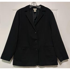 May include: A black blazer with three buttons and two front pockets. The blazer is hanging on a clear plastic hanger. The label on the blazer reads "L.L.Bean".