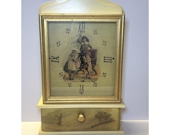 Reloj de pared de madera estilo victoriano vintage con cajón para guardar llaves y diseño en color crema y dorado.