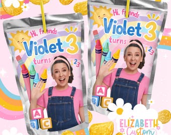 May include: Two custom juice pouches with the text "Hi, friends Violet 3 turns 23" and a photo of a woman. The pouches have a rainbow, crayons, and ABC blocks design. Potato chips and flowers are scattered around the pouches.