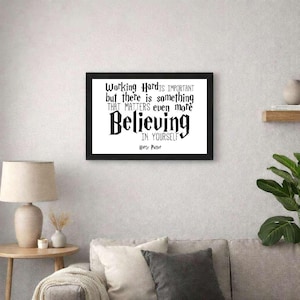 May include: A black framed print featuring the quote "Working Hard is Important but there is something that matters even more Believing in Yourself" in black text on a white background. The print is displayed in a living room setting.