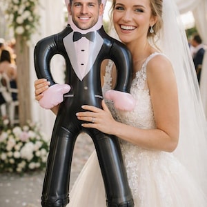 May include: An inflatable novelty doll featuring a printed tuxedo design with a black jacket, white shirt, and black bow tie. The doll has a custom photographic face of a smiling person printed on the head area and light pink cartoon-style hands.