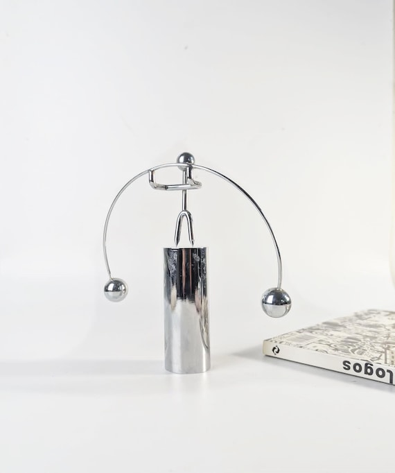 A genuine vintage 1980s postmodern kinetic desk sculpture of a weightlifter — the kind of retro-cool object you'd find in a design museum gift shop, not a big-box store.