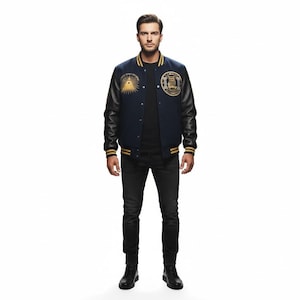 May include: Navy blue varsity jacket with black leather sleeves and gold accents. Features embroidered patches with an eye and owl design. The jacket has a ribbed collar, cuffs, and hem with gold stripes.