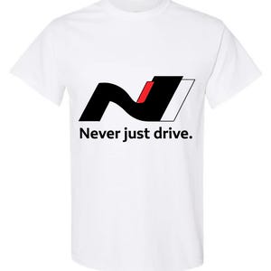 以下が含まれることがあります： 黒と赤の「N」ロゴと白いアウトラインが特徴の白いTシャツ。「Never just drive.」の文字がロゴの下にプリントされています。