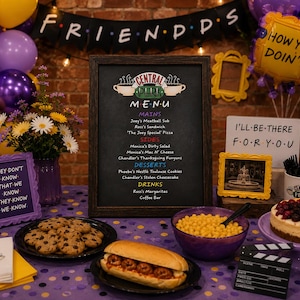 May include: A Central Perk menu sign in a dark wood frame, surrounded by party decorations including purple and yellow balloons, a meatball sub, chocolate chip cookies, a berry cheesecake, a bowl of yellow candies, and a clapperboard.