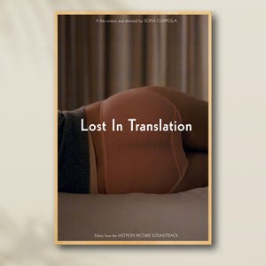 以下が含まれることがあります： 「ロスト・イン・トランスレーション」のフレーム入り映画ポスター。暖色系の色使い。ポスターには、映画のタイトルが白で表示され、桃色の下着を着た人物の画像が使用されています。「A film written and directed by SOFIA COPPOLA」のテキストが上部にあります。