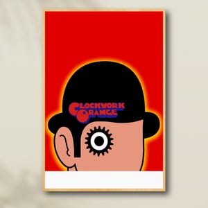 May include: A framed poster featuring a stylized illustration from the film "A Clockwork Orange." The artwork depicts a character's head with a black bowler hat, a gear-shaped eye, and the film's title in red and blue.