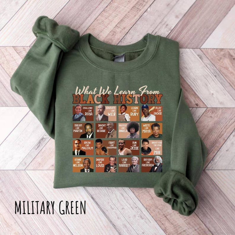 May include: Military green sweatshirt with the text "What We Learn From Black History" and portraits of historical figures. The sweatshirt features a crew neck and long sleeves. The text "MILITARY GREEN" is printed at the bottom.