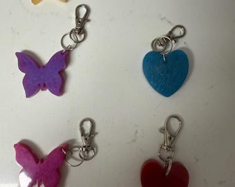Keychains made with resin. Butterfly or heart shaped. Various colors available. Make a great gift!
