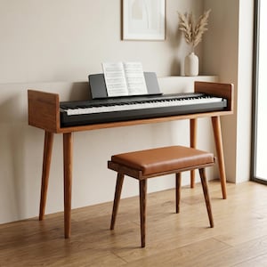 Könnte beinhalten: Ein schwarzes Digitalpiano mit Notenständer und Notenblatt steht auf einem hölzernen Konsolentisch mit vier konisch zulaufenden Beinen. Eine passende Holzbank mit braun gepolstertem Sitz steht vor dem Klavier, das weiße und schwarze Tasten hat.
