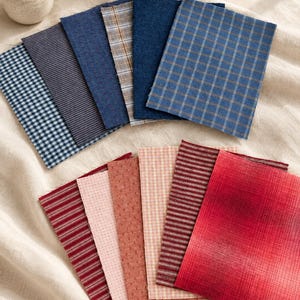 May include: A collection of rectangular fabric swatches arranged in two rows. The top row features blue and grey tones with gingham, pinstripe, solid, and plaid patterns. The bottom row displays red and pink hues with striped and textured designs.