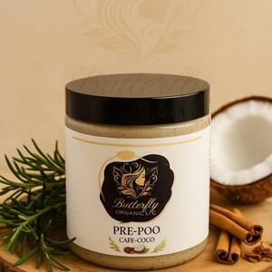 May include: A jar of Butterfly Organic LLC "PRE-POO CAFE-COCO" hair product with a black lid and a white label. The jar sits on a wooden surface with rosemary, cinnamon sticks, and a coconut half. The label features a woman's silhouette.
