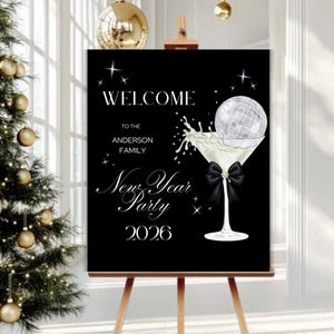 Może przedstawiać: Czarny znak powitalny na sztaludze z napisem "WELCOME TO THE ANDERSON FAMILY New Year Party 2026". Znak przedstawia kieliszek do martini z kulą dyskotekową i czarną kokardą.