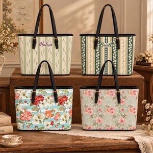 May include: Four tote bags with black leather handles and gold-tone buckles. Top left features green stripes and the name Malisa. Top right has green and white floral stripes with the name Brielle. Bottom left shows red and white flowers on blue stripes. Bottom right displays a pink rose pattern.