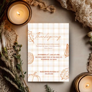 Peut inclure: Carte d'invitation de Thanksgiving avec un fond à carreaux beige et blanc. La carte présente des illustrations d'automne et le texte "Thanksgiving" et les détails de l'événement. La carte est entourée de bougies et d'éléments décoratifs.