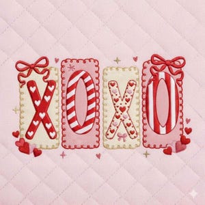 May include: A pink quilted fabric with the letters "XOXO" embroidered in red and white. The "X" letters are decorated with hearts, and the "O" letters have striped patterns. Each letter is framed with a decorative border and topped with a bow.