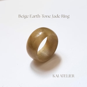 Könnte beinhalten: Ein glatter, polierter Ring aus beigefarbenem Jade in Erdtönen mit abgerundetem Bandprofil. Der Text "Beige Earth-Tone Jade Ring" erscheint oben und der Text "KAI ATELIER" befindet sich unten rechts im Bildrahmen.